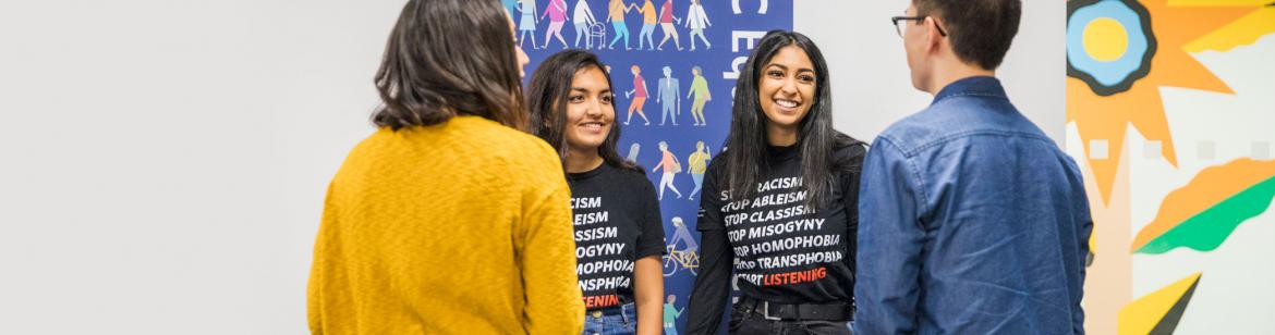 Two Peer Program student leaders engaging with other students at a booth