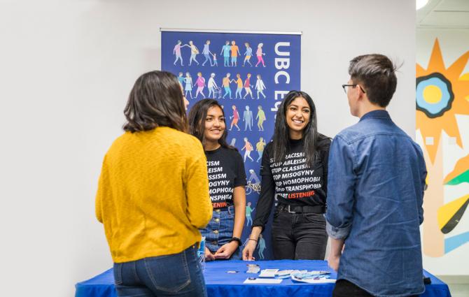 Two Peer Program student leaders engaging with other students at a booth